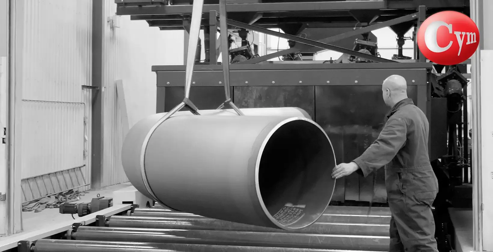 Granalladora CYM EST-ROD 35x17 – operario descargando tubo curvado (bending pipe) de gran diámetro tras el granallado