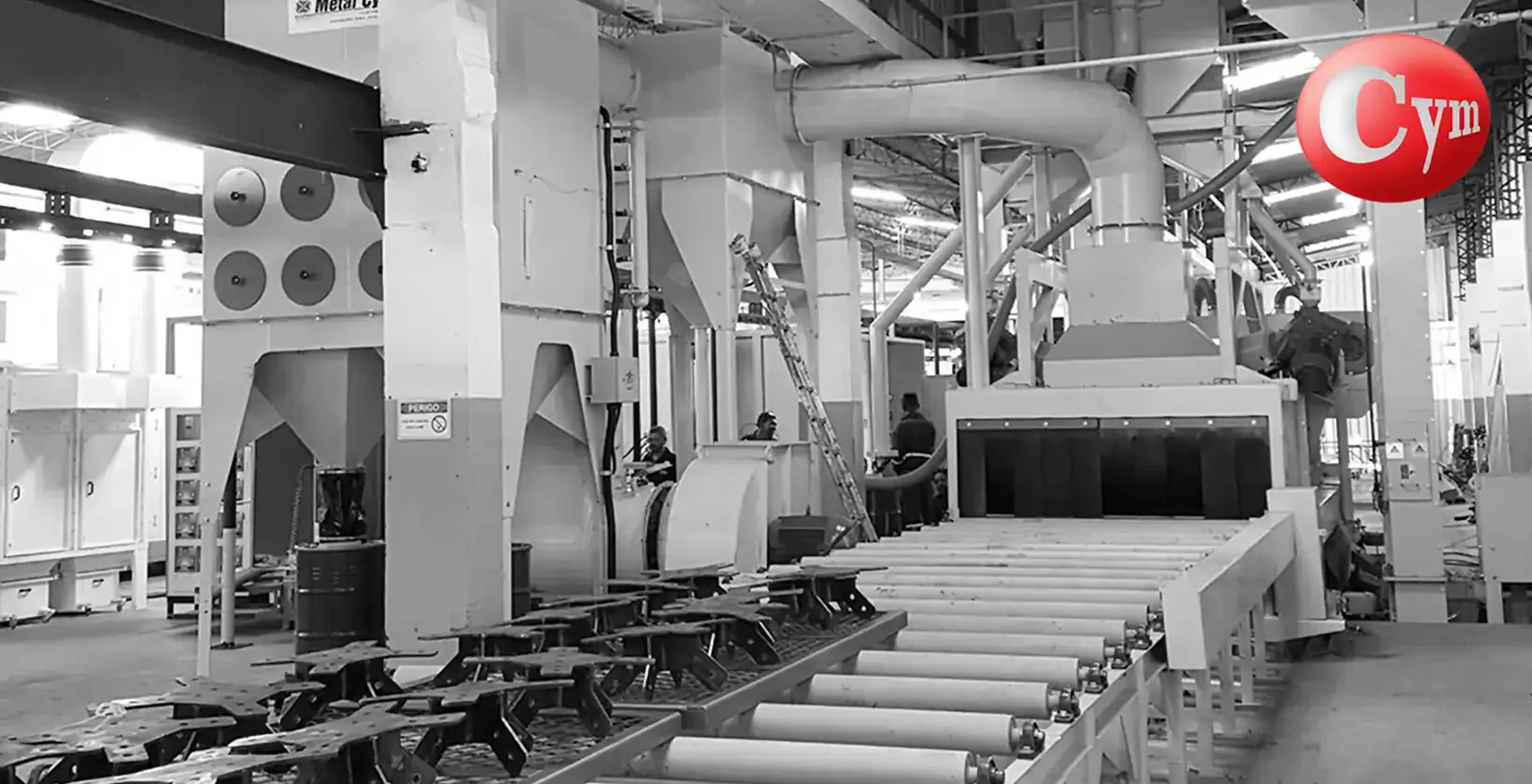 Granalladora CYM PER-I 21x8 con turbinas inclinadas (sección 2.100 mm × 800 mm) – vista desde transportador de entrada con estructura soldada ingresando a cabina