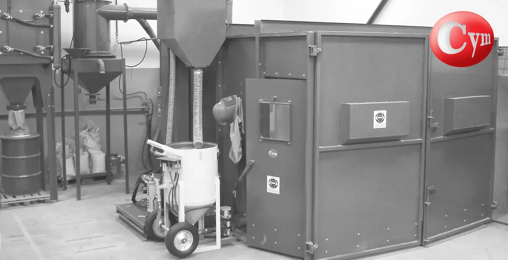 CYM Materiales purificador de granalla ARC Compacto junto a gabinete de granallado en cuarto pequeño con blast pot y tolvas
