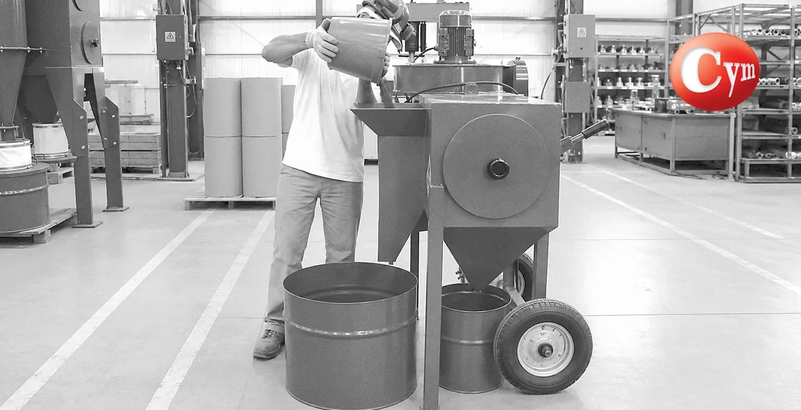 CYM Materiales purificador de granalla ARC ECO operario cargando abrasivo para purificación por cortina granalla-aire